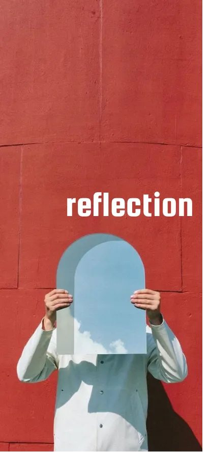 Seseorang memegang cermin di depan dinding merah — reflection