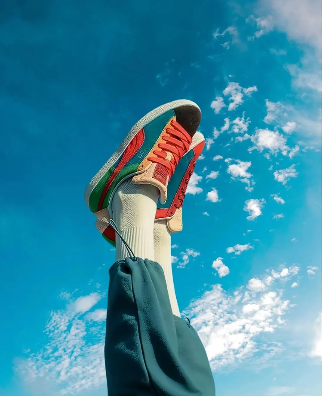 Kaki bersepatu warna-warni terangkat ke langit biru